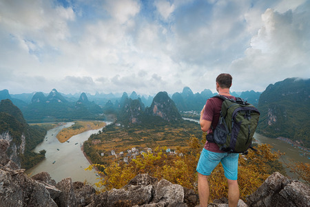 Hiker with backpack on the top of mountain. Xingping, Yangshuo, Chinaの写真素材