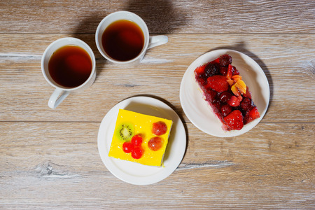 Two cups with tea and two fruits cakes on the wooden table. Overhead view.の写真素材