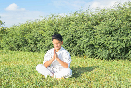 Boy in kimono training in the park. Meditation pose.の写真素材