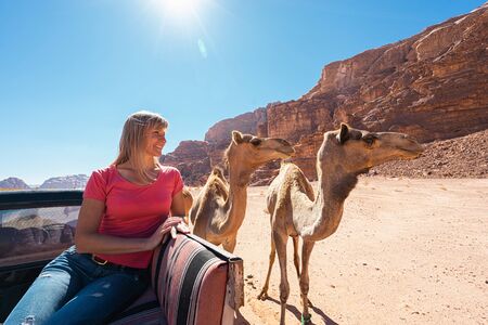 Tourist and camel in desert Wadi Rum, Jordan.の写真素材