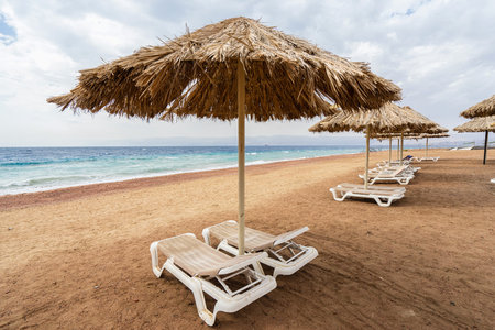 Beach chairs and straw umbrellas. Beach without people in Aqaba, Jordan. 