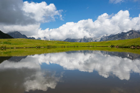 Mountains and clouds reflected in the lake. Beautiful landscape. Lake Koruldi, region Mestia,...