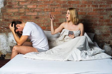 Two upset young partners having domestic quarrel in bedroom.の写真素材