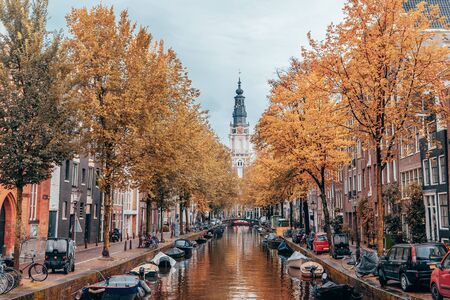 Autumn on a canal in Amsterdam with clock tower in background.の写真素材