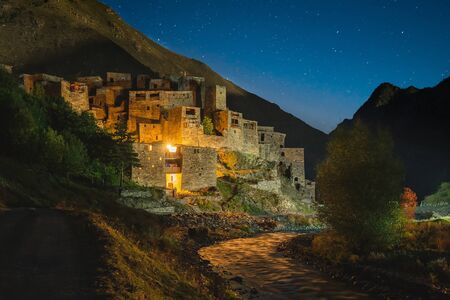 Famous landmark of Hevsureti in Georgia - ruins of medieval village-castle Shatili in nihgt time with stars on the sky.の写真素材