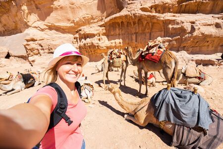 Tourist making selfie with camels in desert.の写真素材