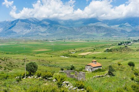 Small church on the valley with mountains on background. Albania.の写真素材