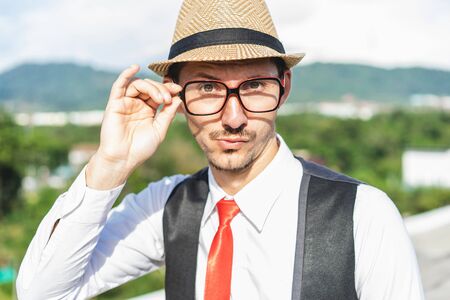 Emotional young man in glasses and hat outdoor. Focus on face.の写真素材
