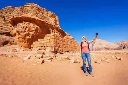 The ruins of Lawrenceâs House and tourist taking selfie in Wadi Rum desert, Jordan.の写真素材