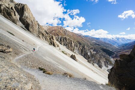 Travel and trekking concept. Hiker with backpack and tourist sticks on trekking trail in himalayas mountains. Nepal.の写真素材