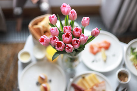 Festive breakfast in the room with flowers. room service. Travel breakfast. birthday morningの写真素材