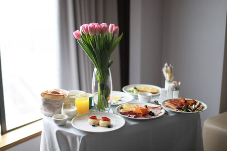 Breakfast in the room, room service. Travel breakfast. Festive breakfast with flowersの写真素材