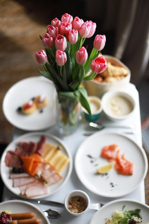 Food in the room, flowers on the table. mother's day. Birthday morning. Breakfast at the hotel with flowersの写真素材
