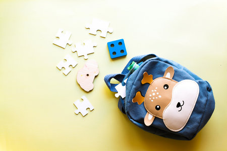 Backpack with toys on a yellow backgroundの写真素材