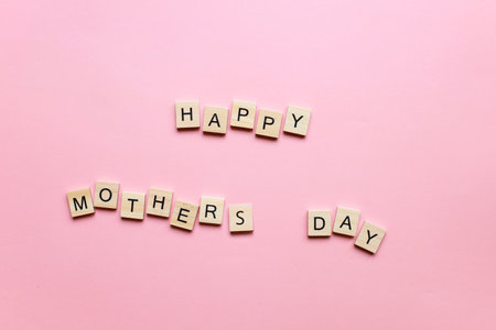 Happy Mothers Day made of wooden letters on a pink background. mother's day cardの写真素材