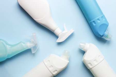 Flat lay cleaning products. Cleaning bottle mockup. Sprays for cleanliness on a blue backgroundの写真素材