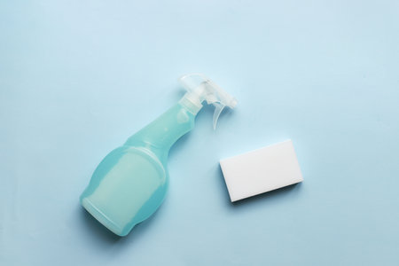 Mockup spray cleaning. Flatly cleaning spray and sponge on blue backgroundの写真素材