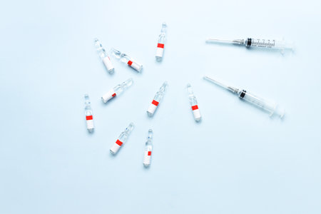 Flat lay ampoules and syringes on a blue background. medical theme. vaccinationの写真素材