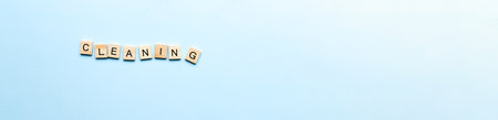 Banner The word cleaning made of wooden letters. Flat lay cleaning from letters on blue backgroundの写真素材