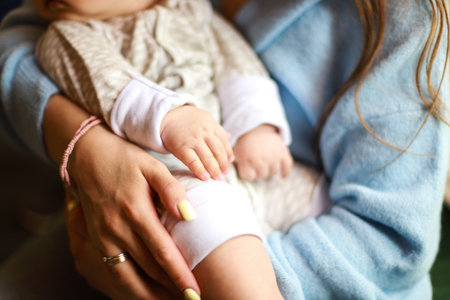 Mom holds the baby in her arms. Mom and baby in a restaurant.の写真素材
