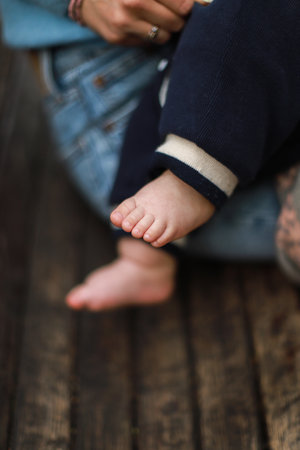 Newborn in mother is arms. Feed the baby. Child is legs. Mom walks with babyの写真素材