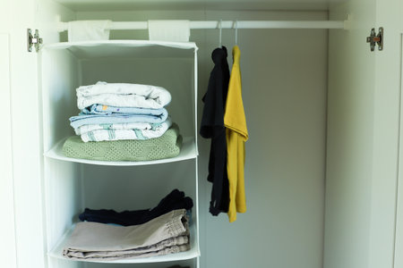 Children is wardrobe. Clothes in the closet. Clothes hang on hangers. Clothes on the shelvesの写真素材