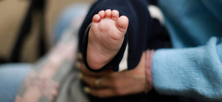 Banner The baby is in the arms of the mother. The newborn sleeps on the street. baby feetの写真素材