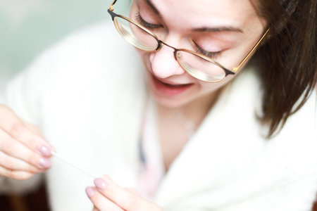 positive pregnancy test. A woman rejoices at a positive test, holding the test in her hands. pregnantの写真素材