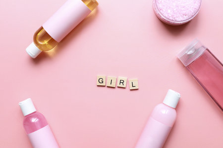 Flat lay word girl from wooden letters on a pink background. bottle mockup. Spa jars. girl care. beauty routineの写真素材