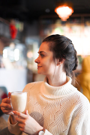 The girl is drinking coffee. Young girl in a restaurantの写真素材