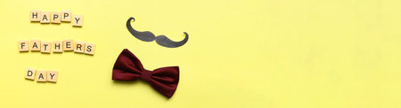 Banner happy fathers day. Flat lay mustache. bow tie on a yellow background. fathers day lettering wordの写真素材