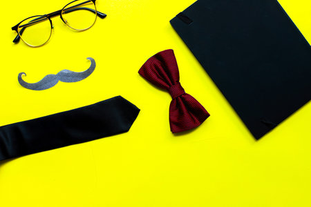 Flat lay fathers day on yellow background. Mockup diary. Tie, glasses, mustacheの写真素材