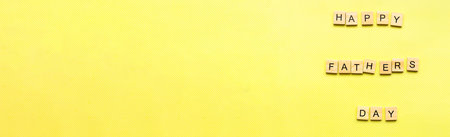 Banner happy fathers day. Father's day in wood lettering. Flat lay happy fathers day on yellow backgroundの写真素材
