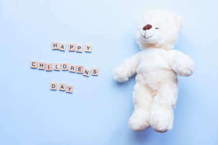 Flat lay Children is Day. white baby bear. Children is day made of wooden lettersの写真素材