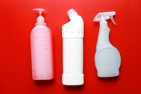 Flat lay cleaning products on a red background. Cleaning bottle mockupの写真素材