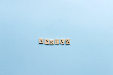The word spring laid out in wooden letters. Flat lay spring on blue backgroundの写真素材