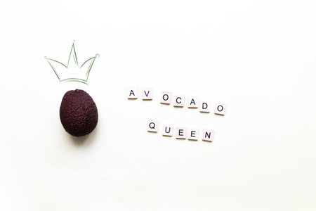 avocado queen. A crown painted on a photo of an avocado. Flat lay lettering avocado queenの写真素材