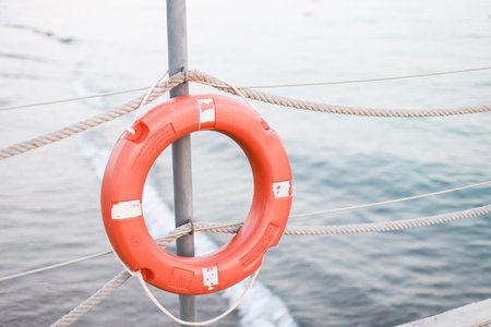 A life jacket hangs on the beach. Orange life jacketの写真素材