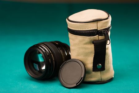 Fast photo lens with cap and pouch on textured backgroundの写真素材