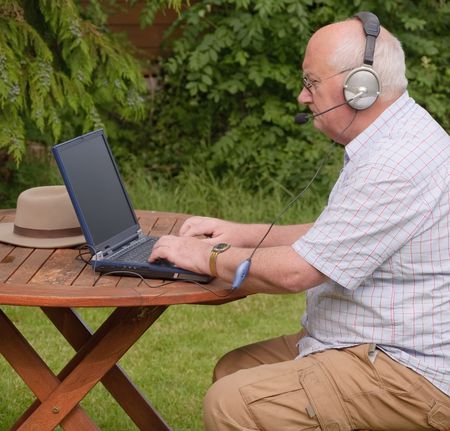 Closeup image of a senior using a laptop outsideの写真素材
