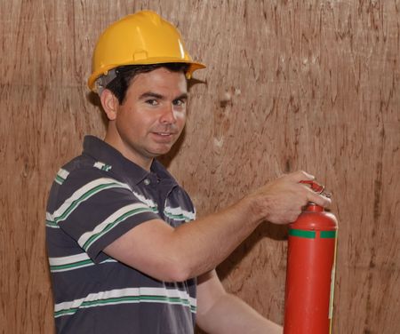 a photo fire extinguisher male pose holdingの写真素材