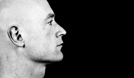 photo high contrast dark moody close up picture of a male head from side on blackの写真素材