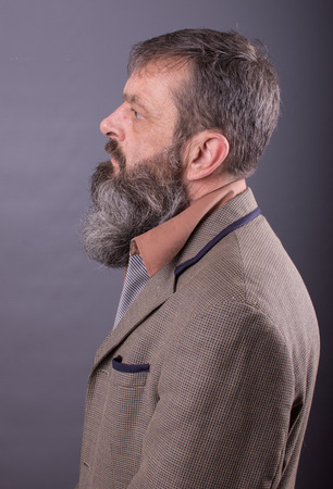 Photo of an angry grumpy old man looking very displeased. Male man with long beard on his face. Close up face looking into the camera.の写真素材