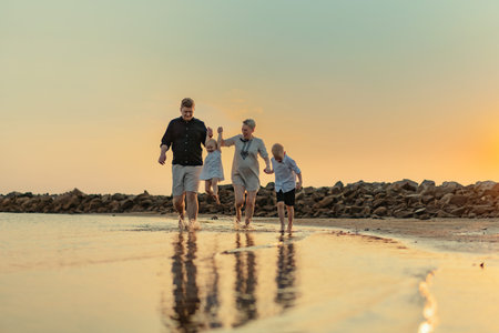 nice caucasian family having fun running in sea on sunset.Summer vacation with kids. high quality...
