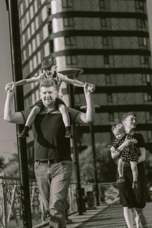 caucasian family couple walking with kids. father carry son on shoulders. high quality photoの写真素材