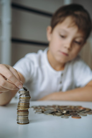 boy making pyramid of coins. ABC of finance. boy counting money. Image with selective focusの写真素材