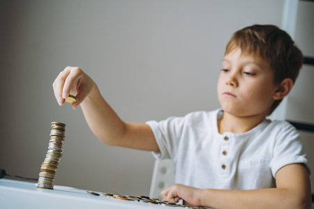 boy making pyramid of coins. ABC of finance. boy counting money. Image with selective focusの写真素材
