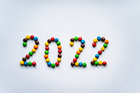 Year 2022 laid out from round multicolored candies on white background. high quality photo