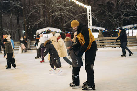 09/01/2022. Saint Petersburg, Russia. People ice-skating in central city park. Father teaching son to skate.のeditorial素材