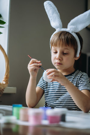 Cute little boy coloring eggs for easter. Image with selective focus